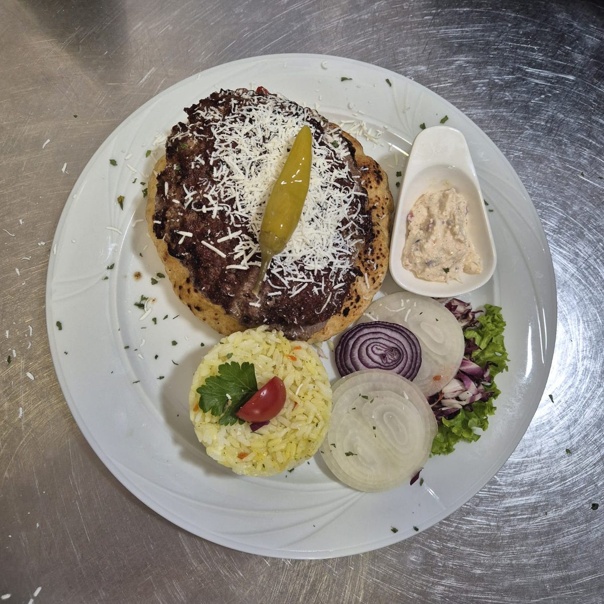 Pljeskavica sa rizom — patty with grated cheese, rice & onions