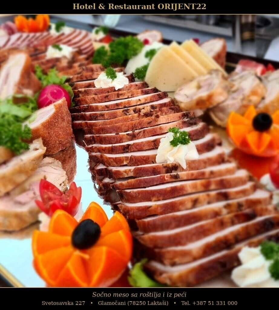 Catering platter of grilled and oven-roasted sliced meats with cheese and garnish
