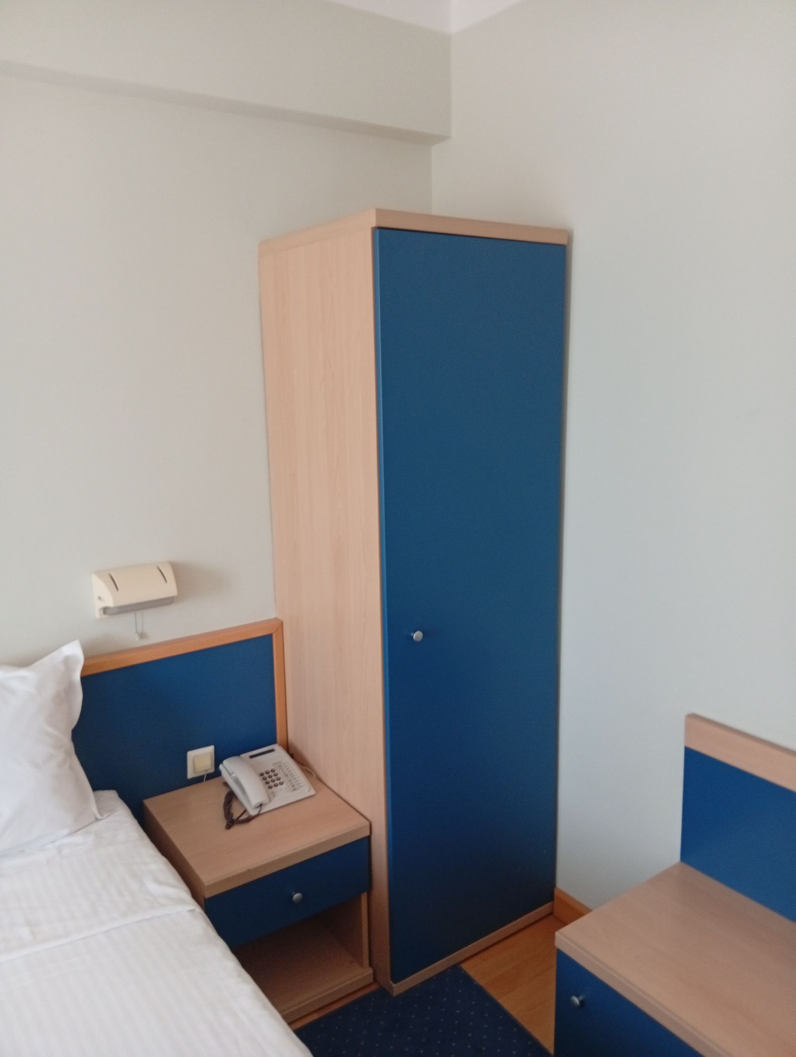 Bedside table, telephone and wardrobe